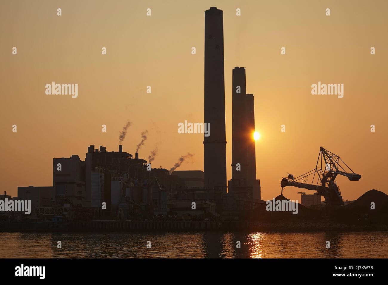 Una silhouette di una centrale elettrica a carbone al tramonto, Isola di Lamma, Hong Kong; Yung Shue WAN, Isola di Lamma, Hong Kong, Cina. Foto Stock