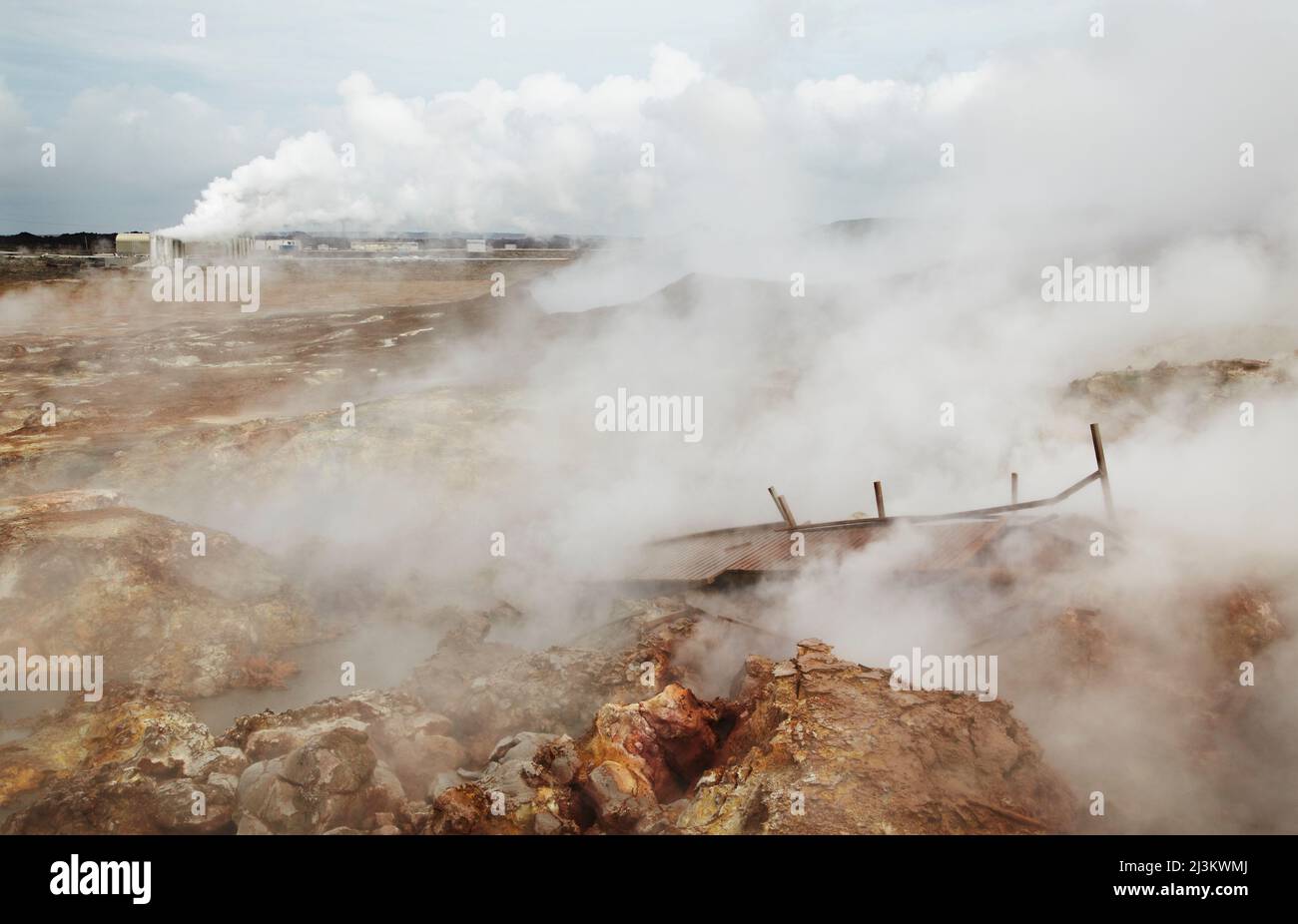 Campo geotermico di Gunnuhver, con un impianto geotermico alle spalle, Islanda; Reykjanesviti, penisola di Reykjanes, Islanda. Foto Stock