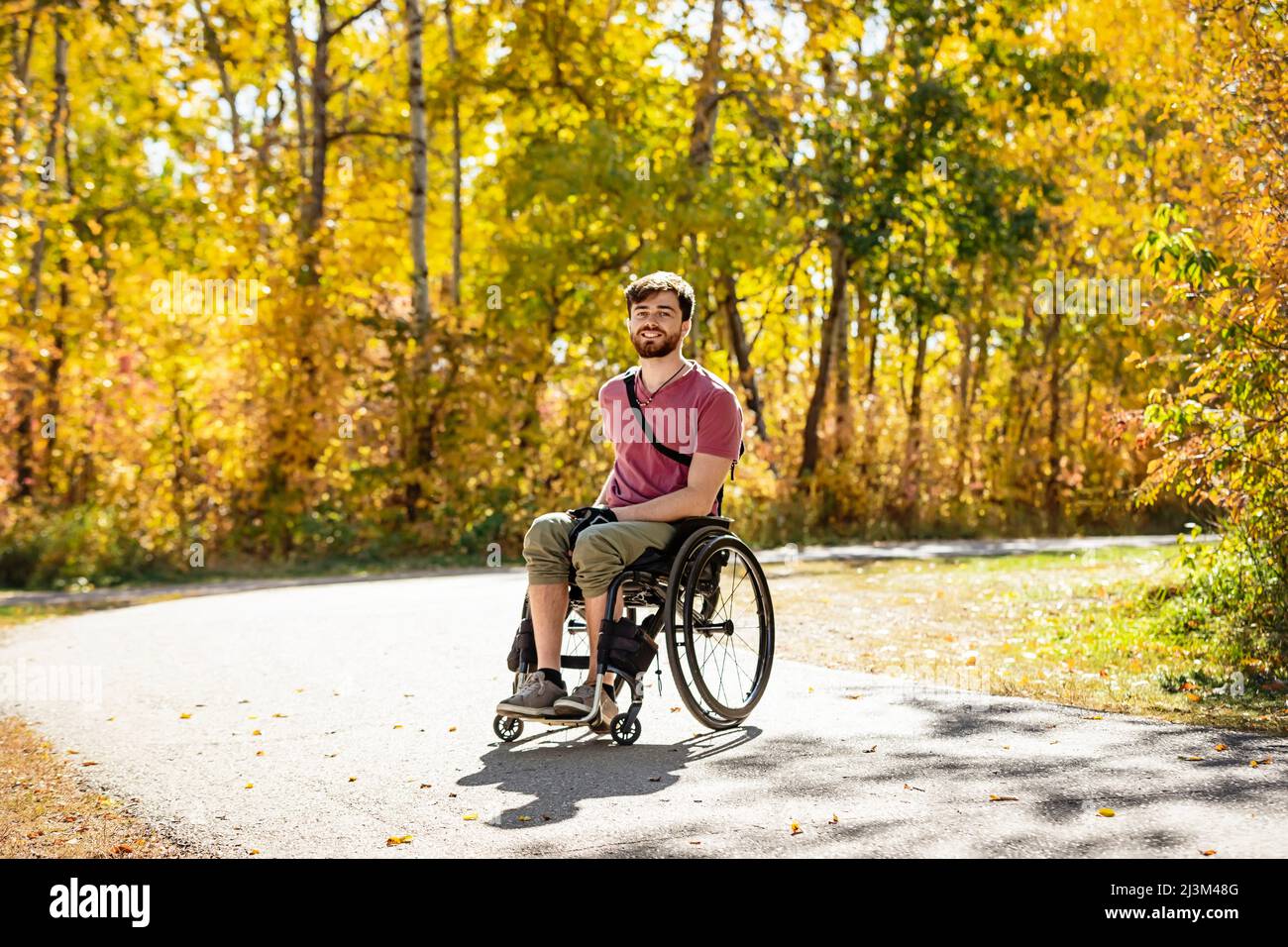 Ritratto di un paraplegico in una sedia a rotelle all'aperto in un parco in autunno; Edmonton, Alberta, Canada Foto Stock