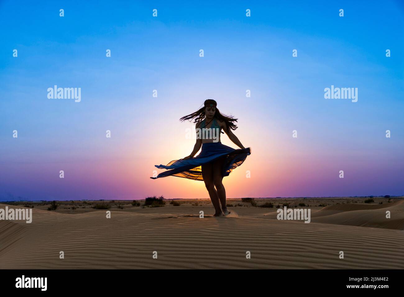 Ballerina sulle sabbie del deserto al tramonto; Abu Dhabi, Emirati Arabi Uniti Foto Stock