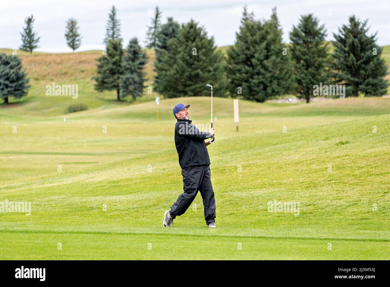Amputee con protesi ad un braccio che fa un'oscillazione sul campo da golf; Okotoks, Alberta, Canada Foto Stock