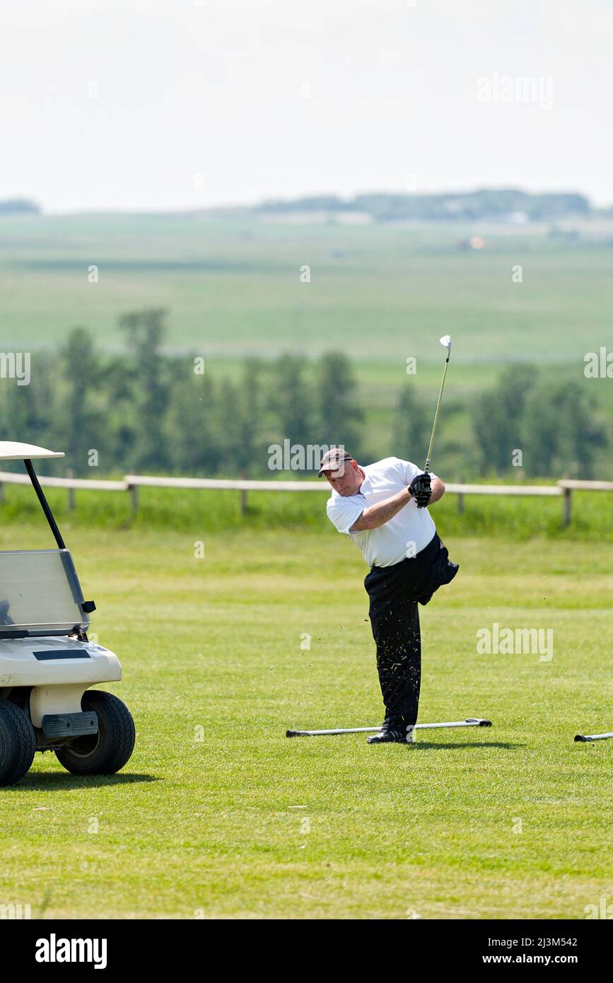 Amputee che prende un'oscillazione sul campo da golf; Okotoks, Alberta, Canada Foto Stock