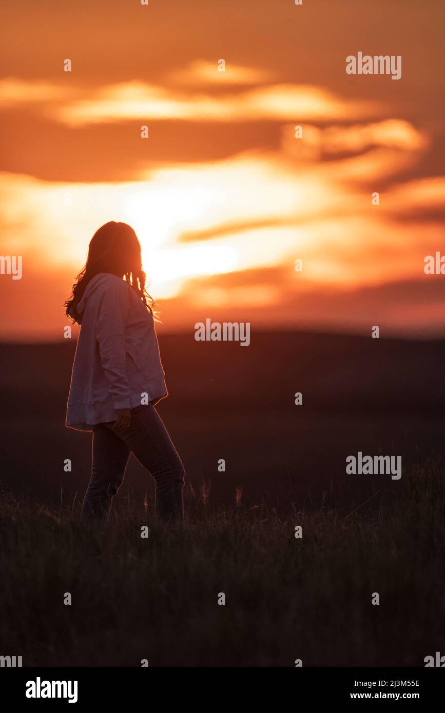 Donna che gode il tramonto sulle praterie del Saskatchewan meridionale; Val Marie, Saskatchewan, Canada Foto Stock