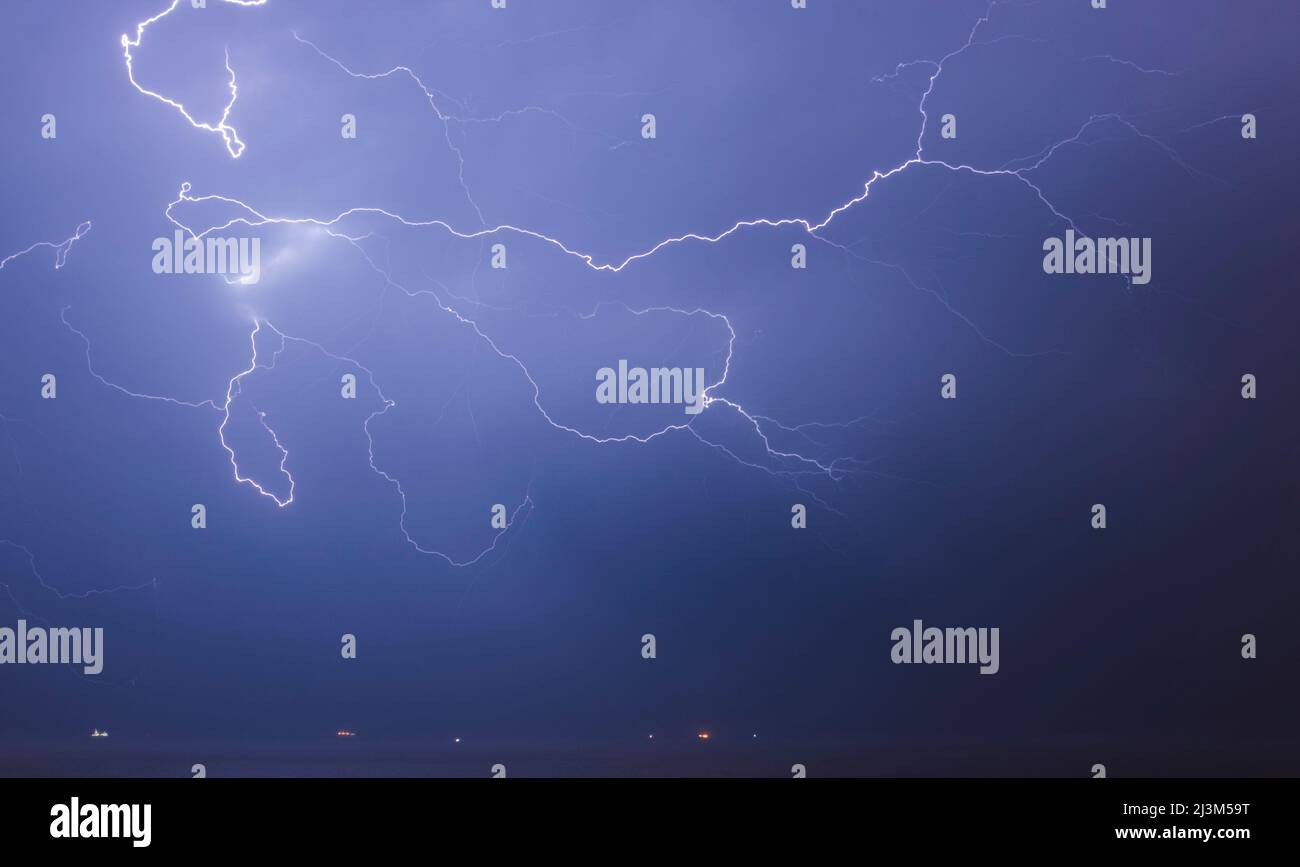 Un fulmine spettacolare raggiunge fuori dalla nuvola e attraverso il cielo sopra la Manica verso Brighton sulla costa sud dell'unità... Foto Stock