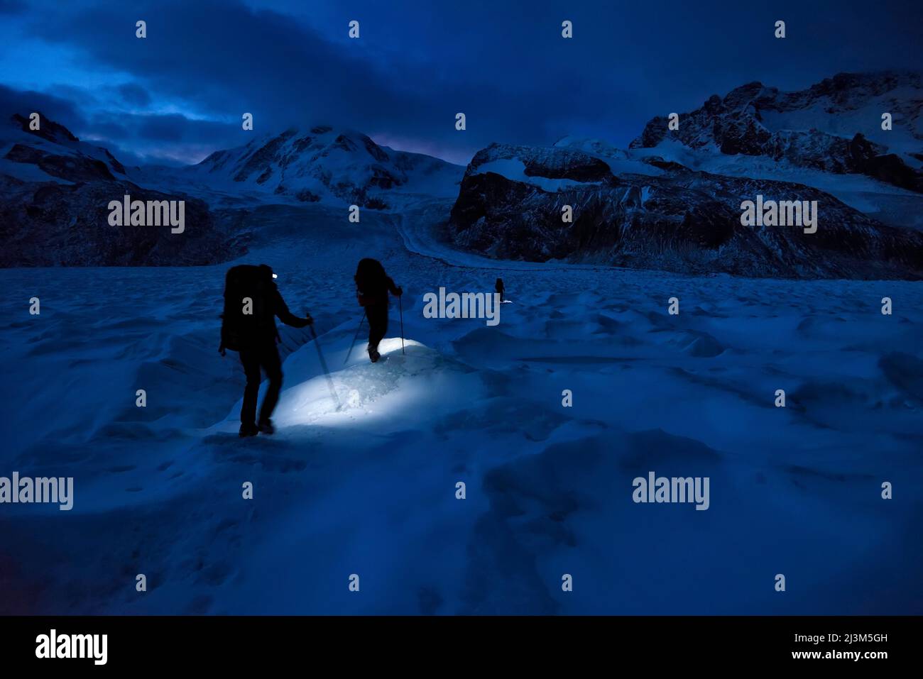 Esploratori della grotta che camminano sul ghiacciaio alla ricerca di nuovi moulins inesplorati sul Gorner Glacier; Gornergrat, Zermatt, Svizzera. Foto Stock