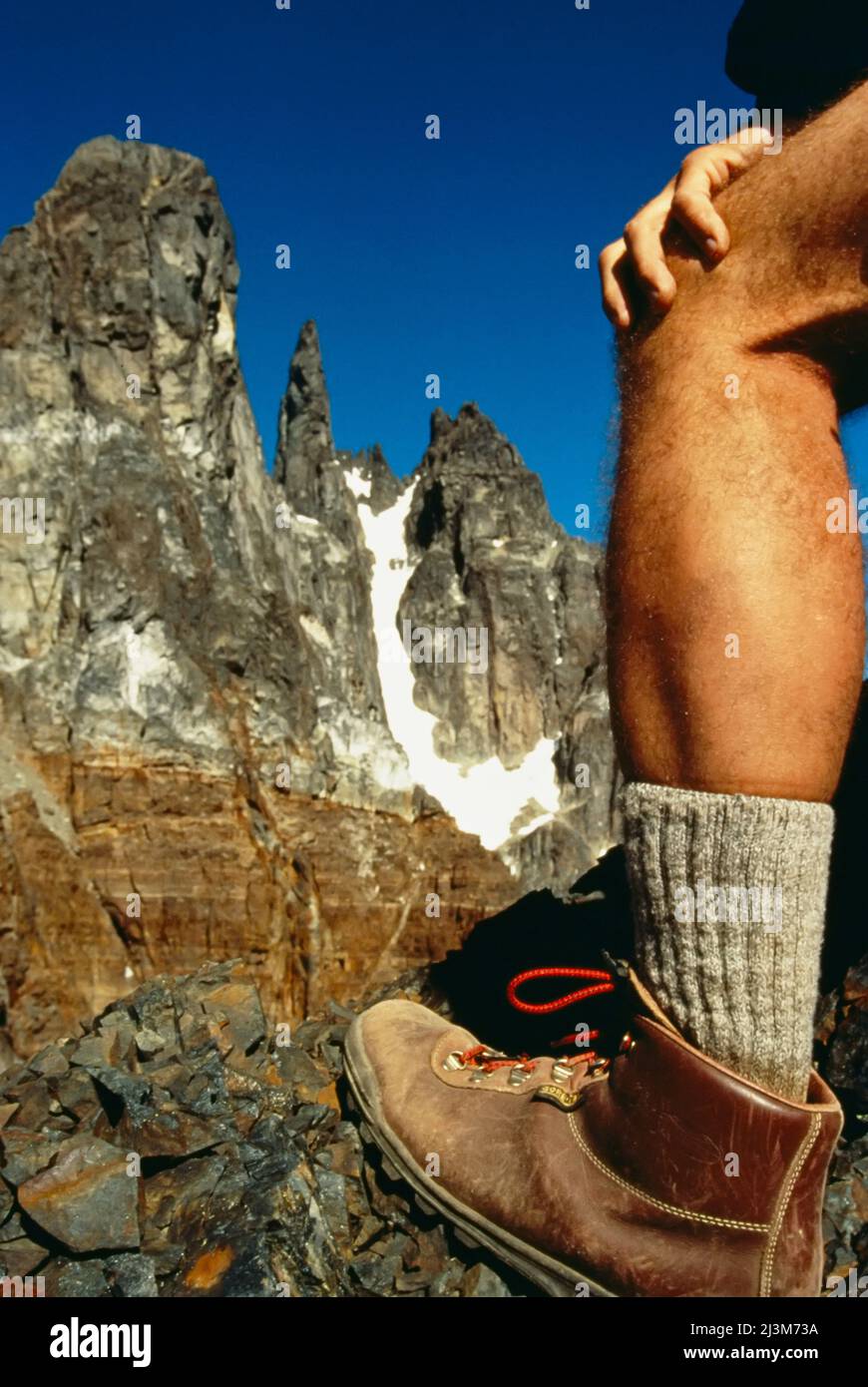 Gamba dell'escursionista durante la pausa alla base delle cime di granito nelle Ande.; Cile. Foto Stock