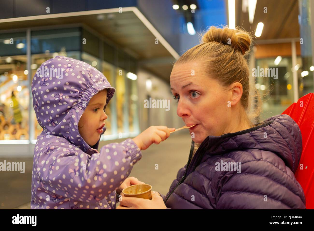 Madre e giovane figlia condividono uno spuntino a Lonsdale Quay, North Vancouver; North Vancouver, British Columbia, Canada Foto Stock