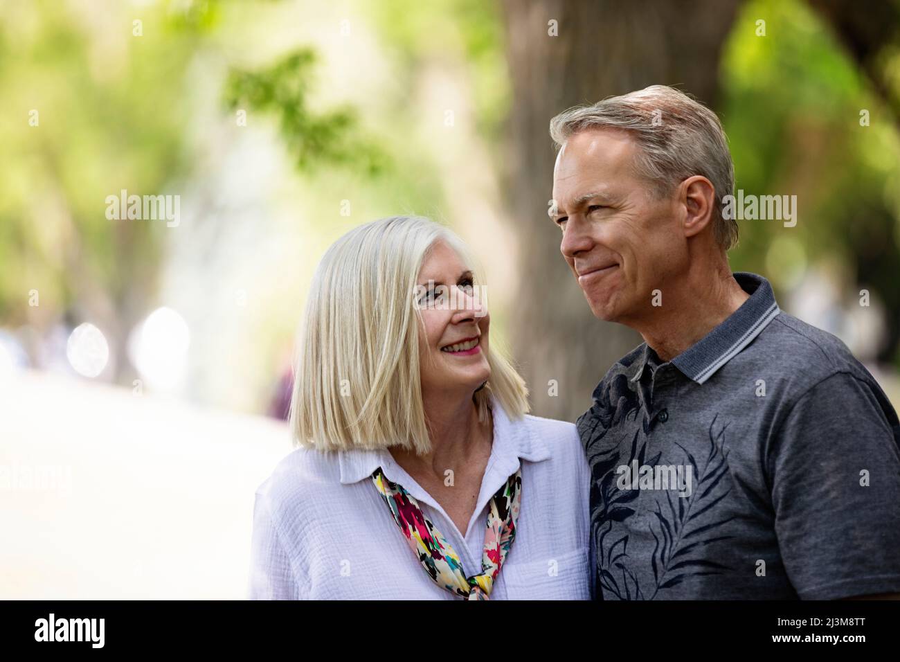 Ritratto all'aperto di una coppia matura in un parco, la moglie che guarda il marito; Edmonton, Alberta, Canada Foto Stock