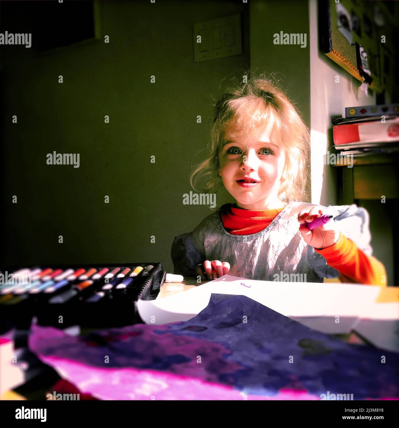 Una ragazza di tre anni al suo tavolo d'arte usa i marcatori per un progetto d'arte.; Cabin John, Maryland. Foto Stock