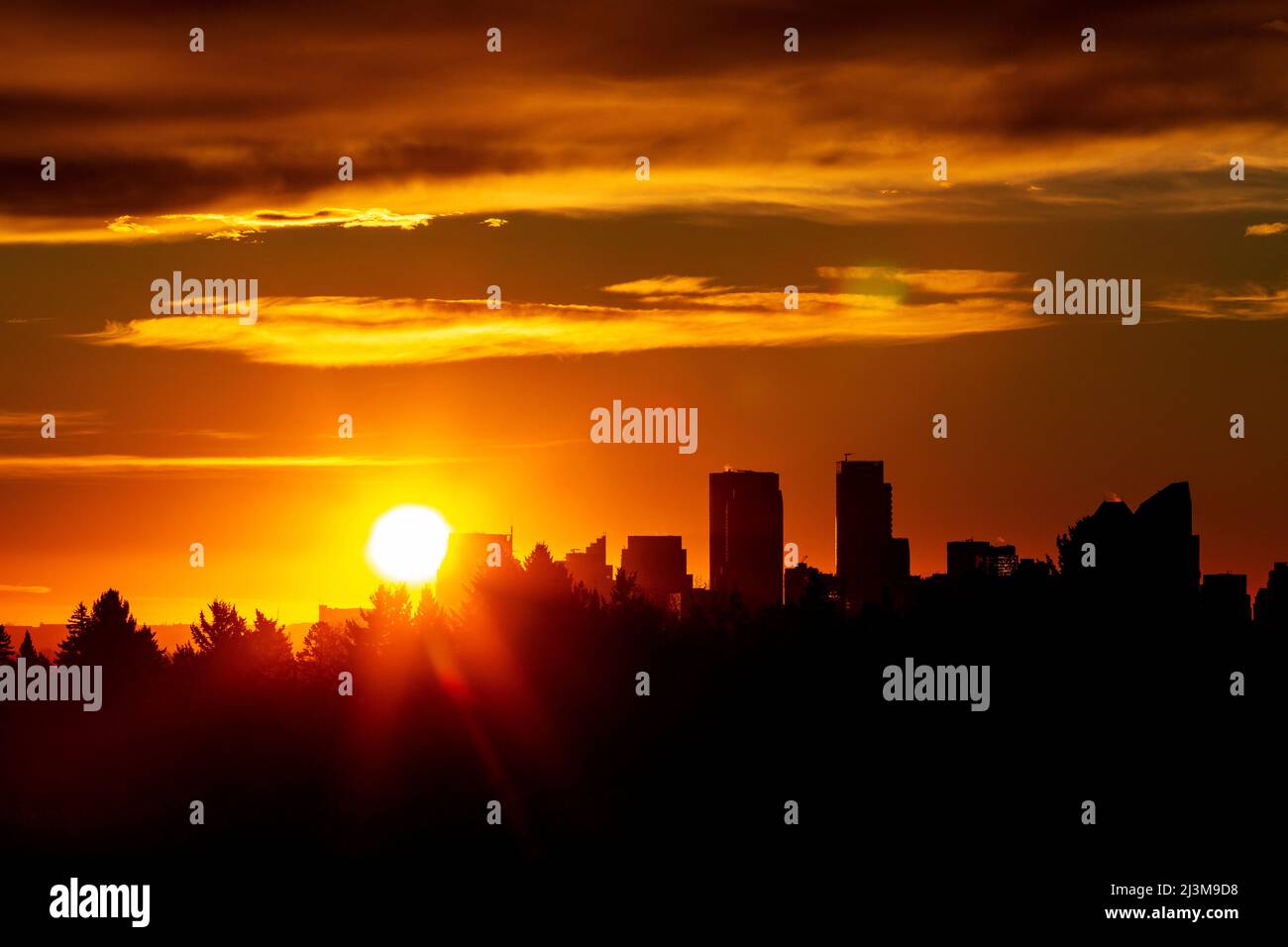 Spettacolare cielo colorato con un paesaggio urbano e un'esplosione di sole; Calgary, Alberta, Canada Foto Stock