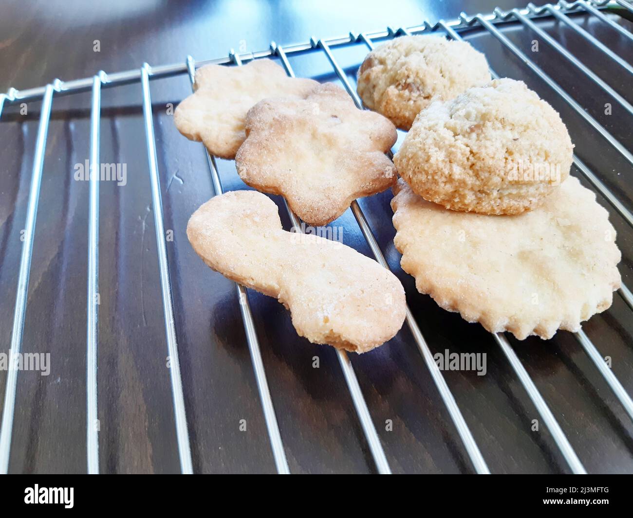 Biscotti fatti in casa, secchi. Sfondo verde con griglia da forno in metallo. Primo piano biscotti fatti in casa. Foto Stock