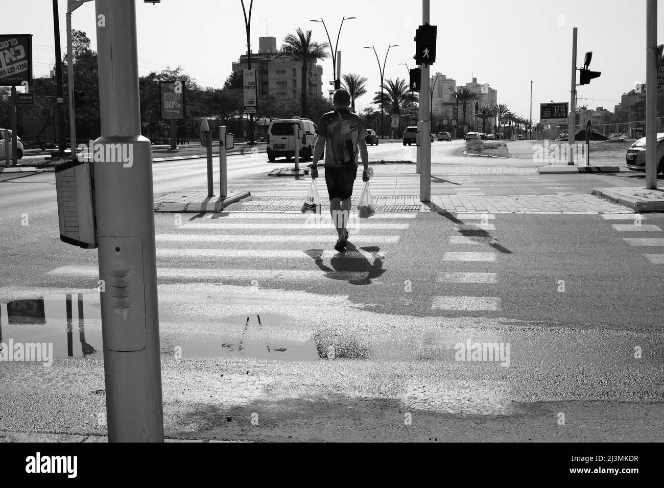 uomo che attraversa la strada Foto Stock