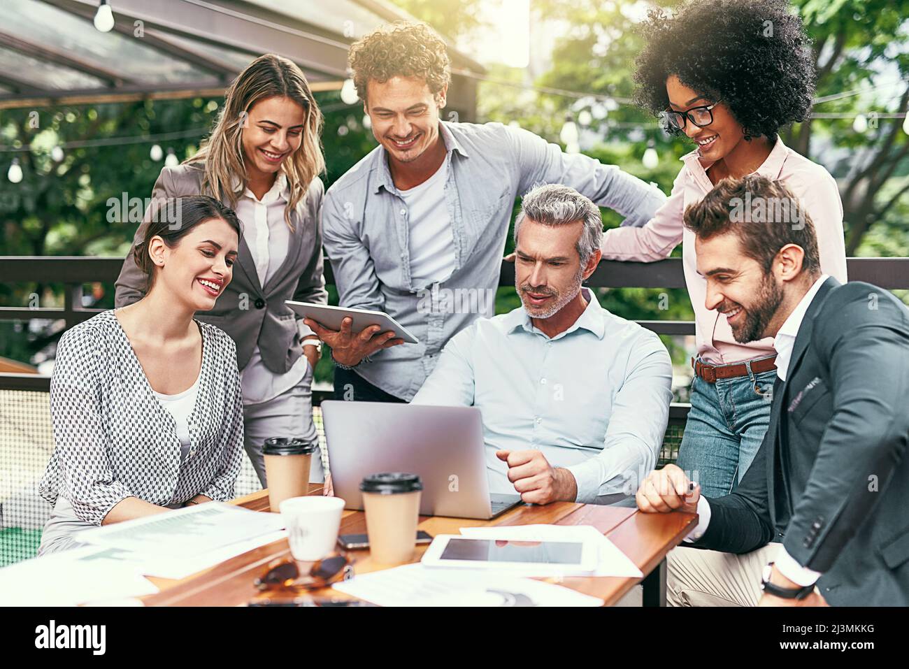 Produttività e lavoro di squadra al massimo. Foto di un team di colleghi che utilizzano un notebook insieme durante una riunione all'aperto. Foto Stock