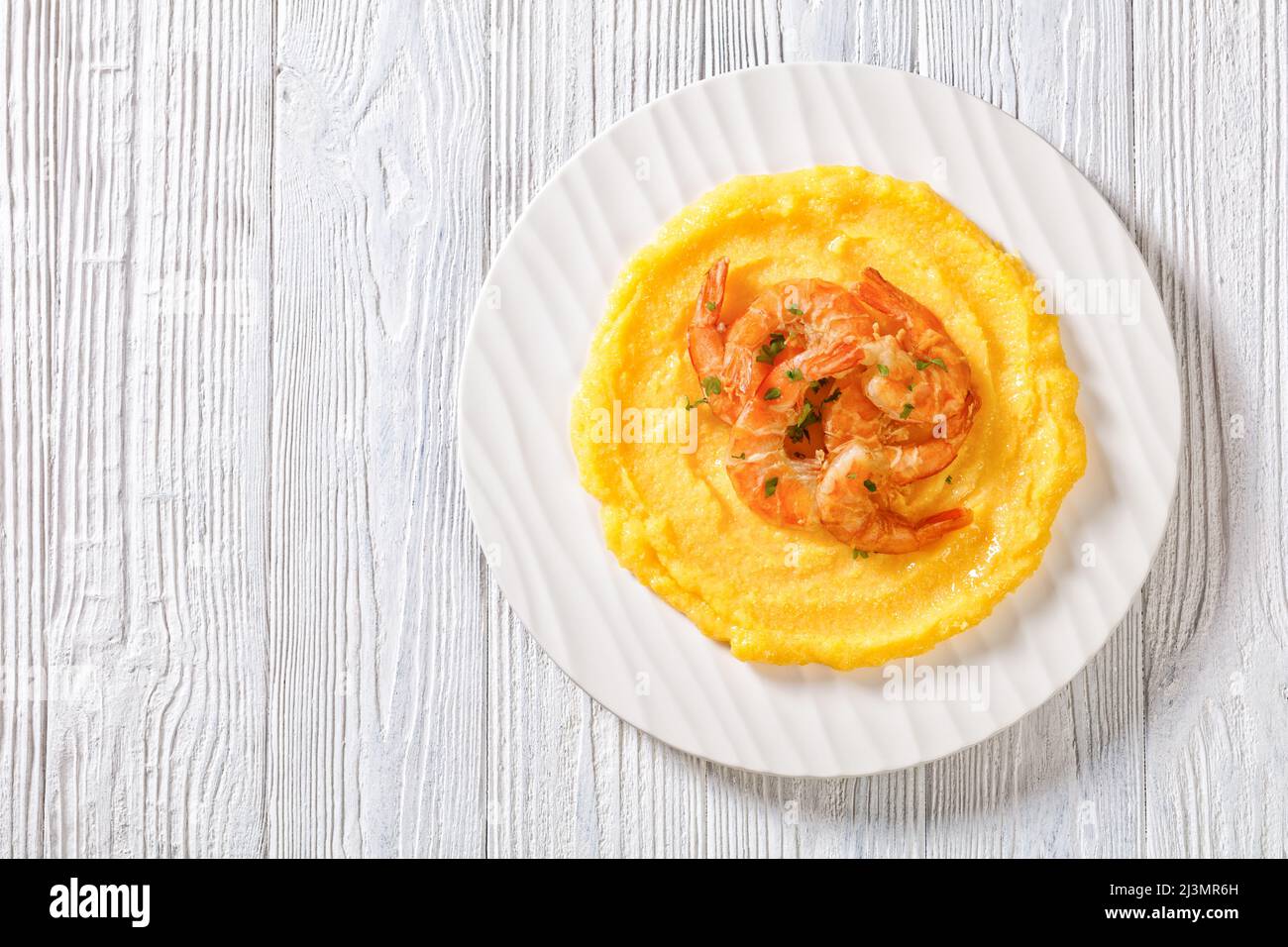 Polenta e schie fritte, piatto veneziano, polenta con gamberi fritti su piatto bianco su tavola in legno testurizzato, vista orizzontale dall'alto, piatto, gratuito Foto Stock