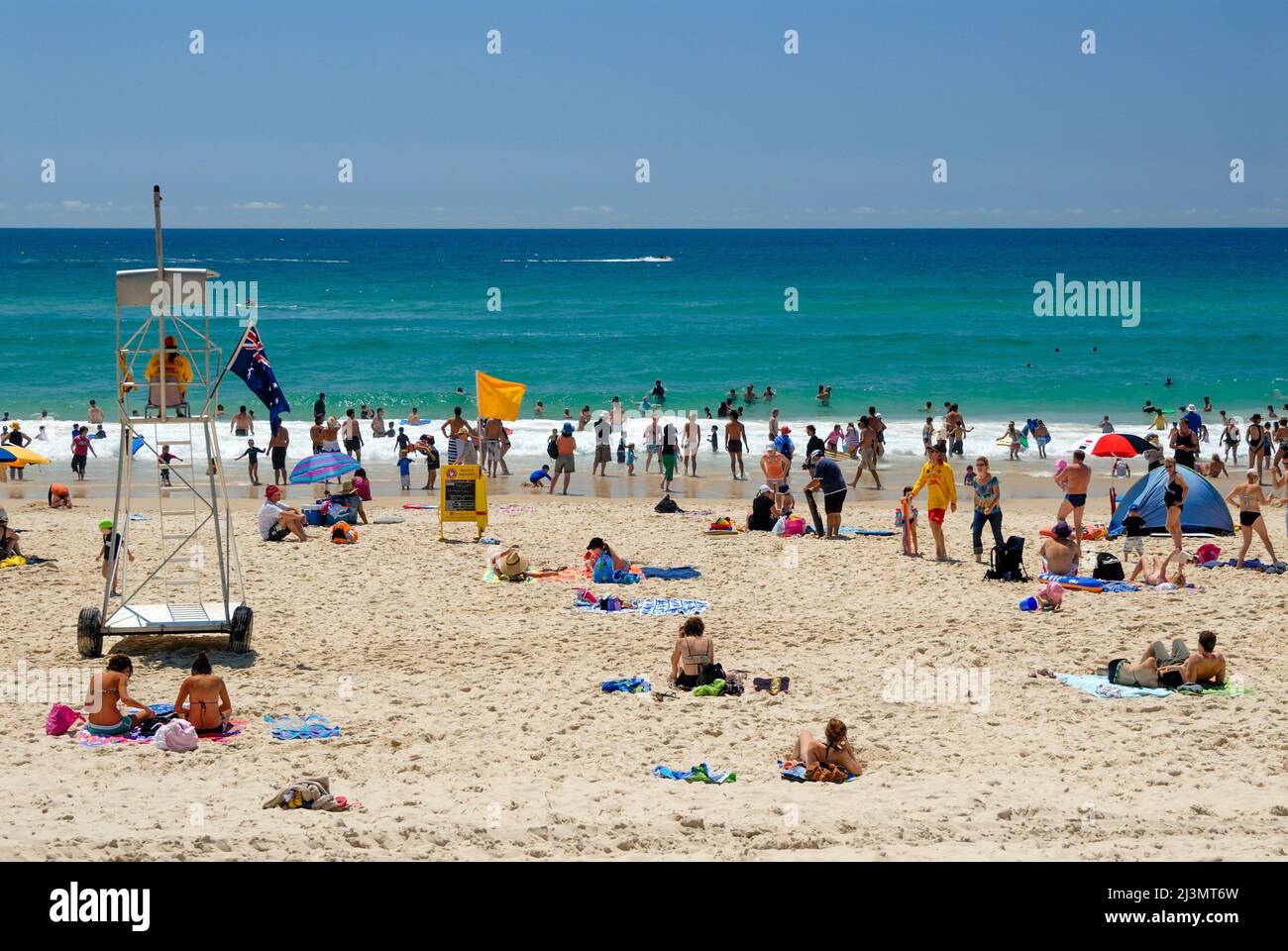 Beach goers su una spiaggia pattugliata in Surfers Paradise. Foto Stock