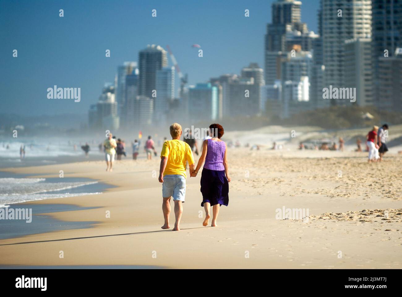 Coppia matura che cammina a mano sulla spiaggia di Surfers Paradise. Foto Stock