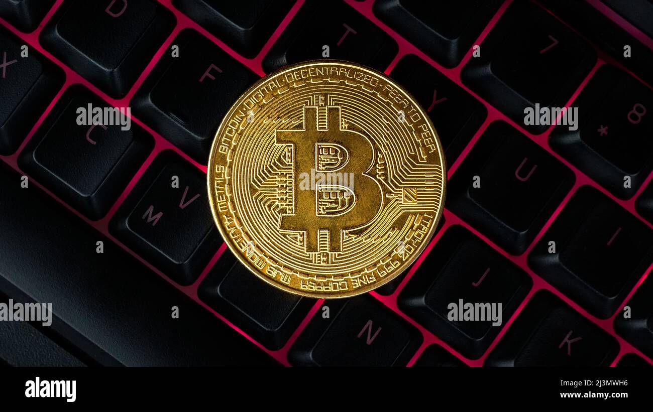 Bitcoin sulla tastiera compuer in background, simbolo di elettronici di denaro virtuale e data mining cryptocurrency concetto. Coin moneta crypto bitcoin giace sul Foto Stock