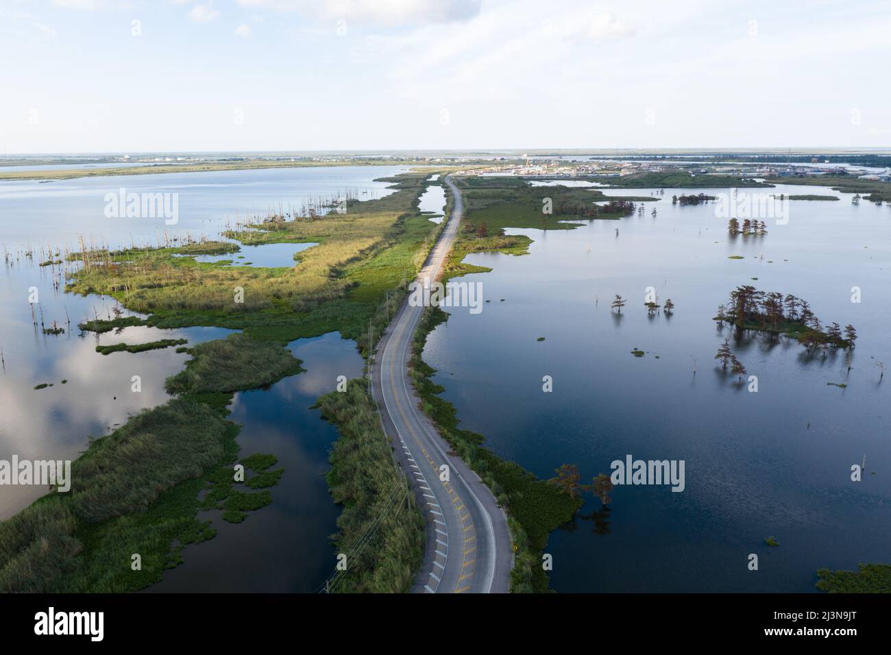 Vista aerea di un'auto che attraversa una strada in una palude della Louisiana, vicino al delta del fiume Mississippi. Foto Stock