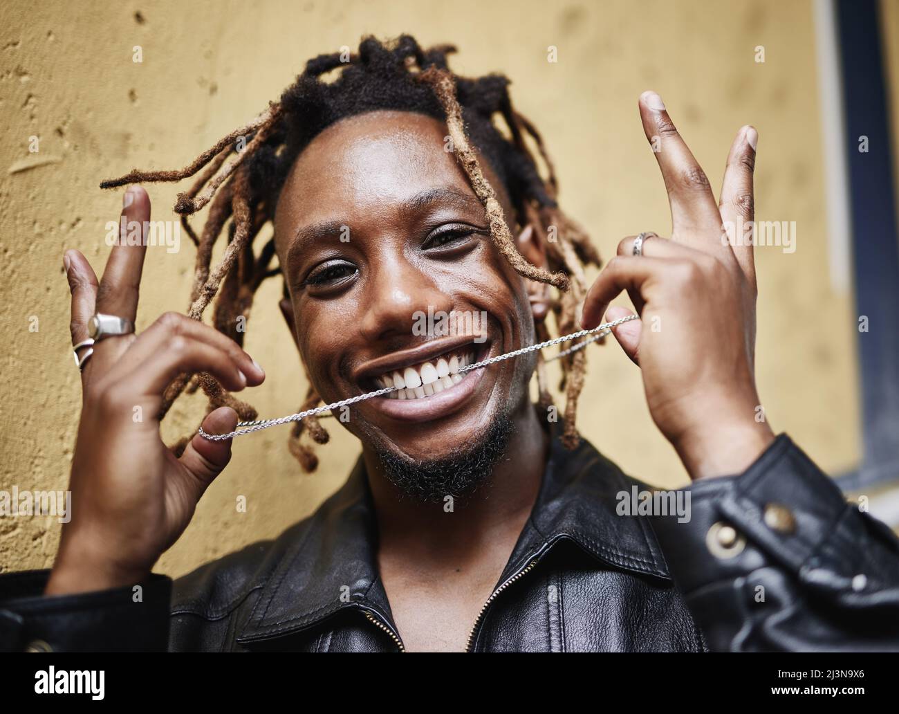 Oro massiccio. Ritratto corto di un bel giovane gangster maschile che mostra la sua catena mentre fuori per strada. Foto Stock
