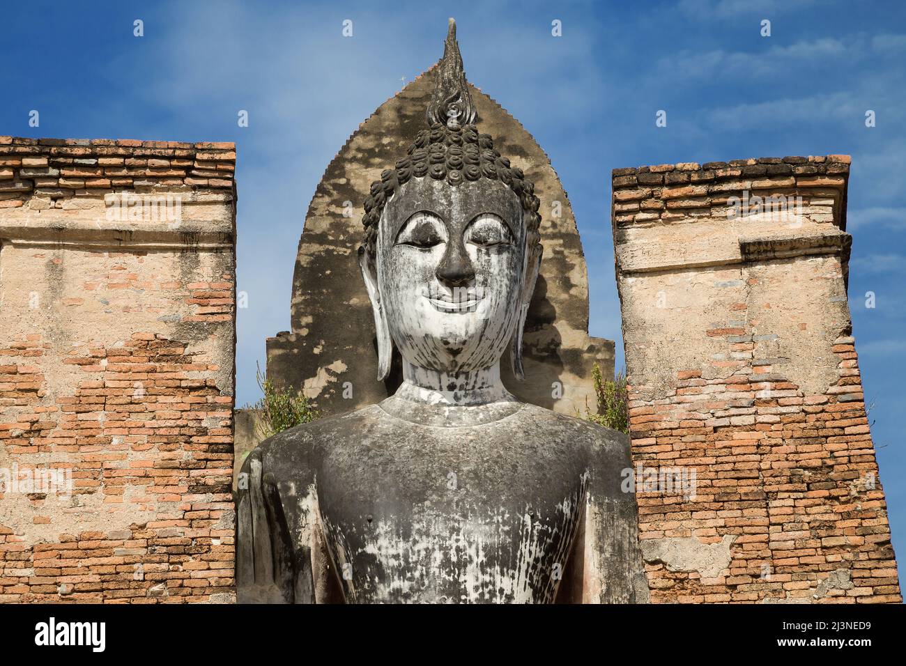 Faccia del Buddha in piedi a Wat Mahathat in Sukhothai, Thailandia. Foto Stock