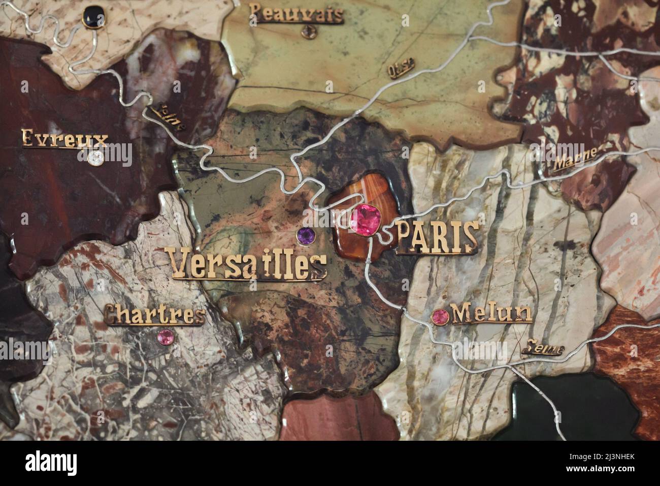 Parigi e Versailles segnate con pietre preziose e fiumi di platino sul dettaglio della carta a mosaico in pietra della Francia prodotta da artigiani russi in mostra presso l'Château de Compiègne di Compiègne, Francia. La mappa del mosaico è stata realizzata da pietre preziose e semipreziose di Ural da artigiani russi guidati dall'artigiano Danila Zverev e dall'ingegnere Vasily Mostovenko presso la fabbrica del Lapidario Imperiale di Yekaterinburg, Impero Russo. La mappa fu esposta all'esposizione universale di Parigi nel 1900 e fu regalata allo Stato francese durante la visita dello zar Nicola II di Russia al Château de COMPI Foto Stock
