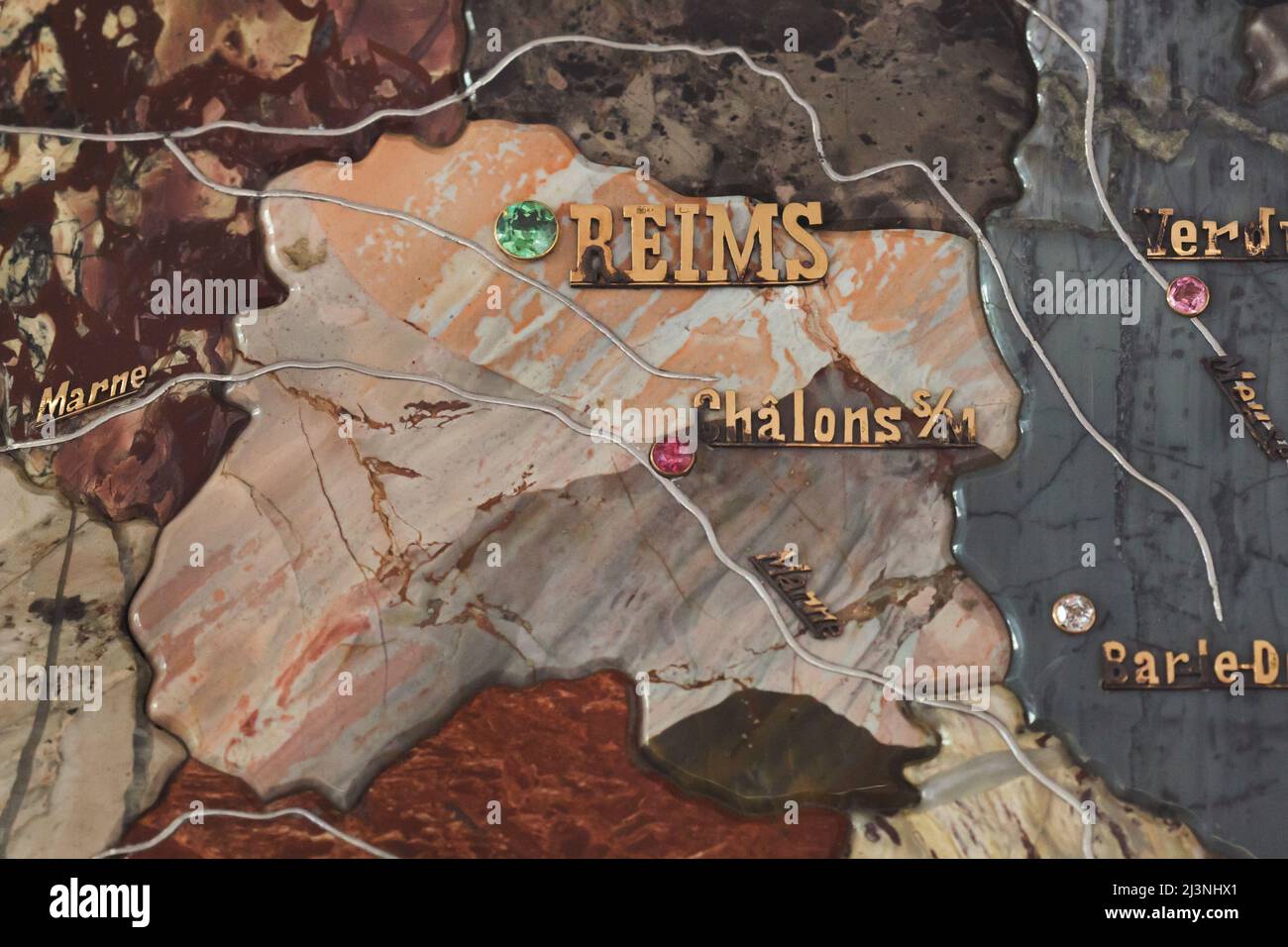 Reims segnato con una pietra preziosa verde e il fiume Marne segnato con platino sul dettaglio della mappa mosaico di pietra della Francia prodotto da artigiani russi in mostra al Château de Compiègne in Compiègne, Francia. La mappa del mosaico è stata realizzata da pietre preziose e semipreziose di Ural da artigiani russi guidati dall'artigiano Danila Zverev e dall'ingegnere Vasily Mostovenko presso la fabbrica del Lapidario Imperiale di Yekaterinburg, Impero Russo. La mappa fu esposta all'esposizione Universelle di Parigi nel 1900 e fu regalata allo stato francese durante la visita dello zar Nicola II di Russia al Châ Foto Stock
