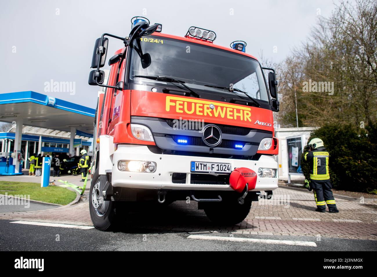 Wittmund, Germania. 09th Apr 2022. Un veicolo di emergenza del Dipartimento dei vigili del fuoco di Wittmund si trova in una stazione di servizio dove il serbatoio di un veicolo a gas naturale era esploso in precedenza durante il rifornimento. Secondo la polizia, una persona che ha rifornito l'auto è stata ferita nell'esplosione. Credit: Hauke-Christian Dittrich/dpa/Alamy Live News Foto Stock