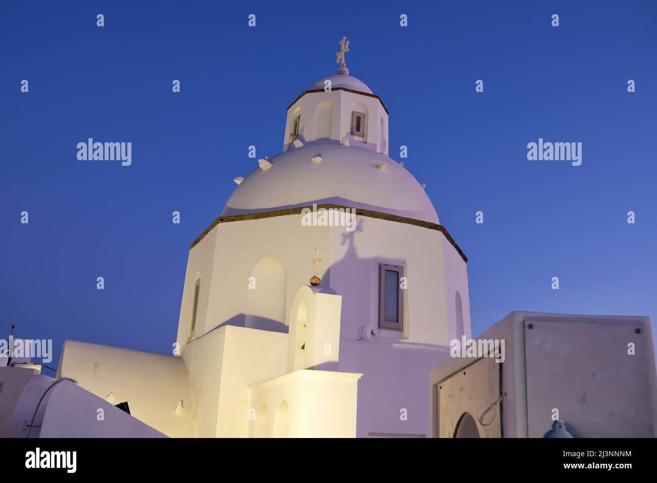 Vista di una tipica ma stupefacente chiesa greca illuminata a Fira Santorini Foto Stock