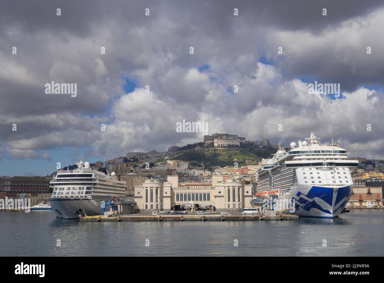 Vista di Napoli dal porto con una nave da crociera ormeggiata e un traghetto Campania Italia Foto Stock