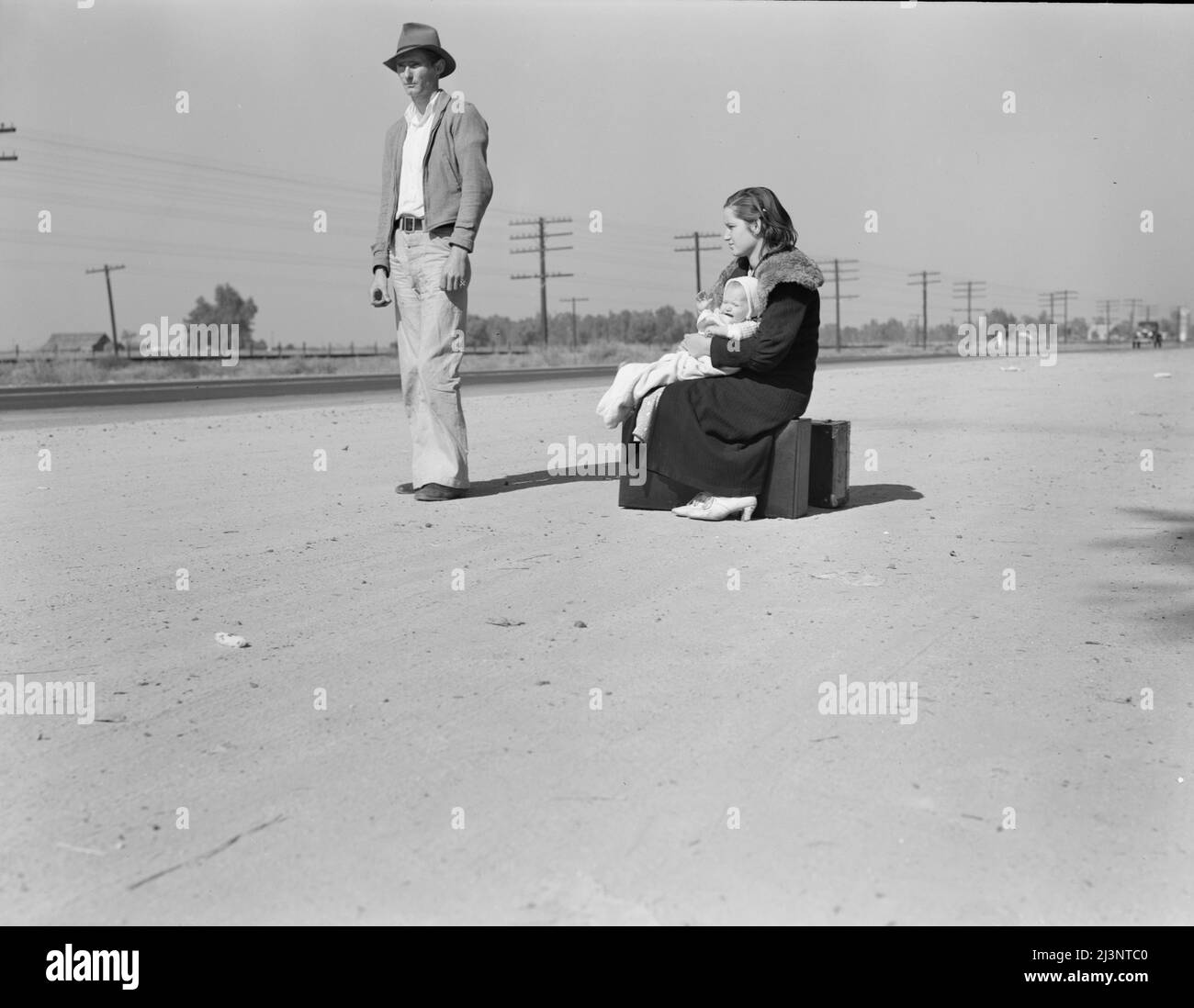 Famiglia giovane, penniless, hitchhiking sulla US Highway 99, California. Ventiquattro il padre e diciassette la madre provenivano da Winston-Salem, Carolina del Nord, all'inizio del 1935. Il loro bambino è nato nella Valle Imperiale, California, dove lavoravano come operai di campo. Foto Stock