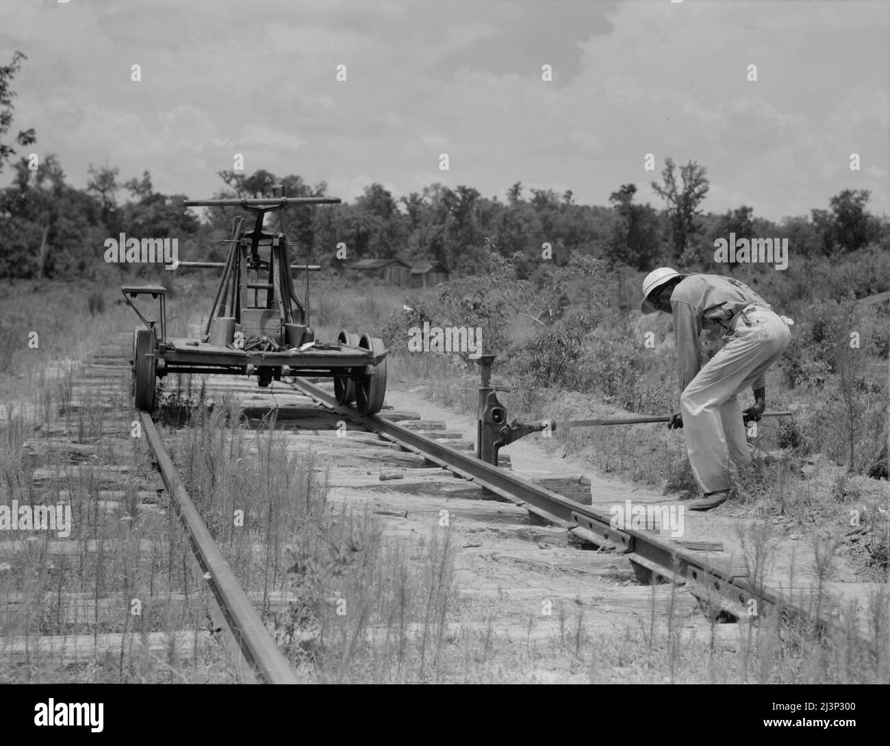 Tirando fuori le rotaie che conducono alla segheria chiusa. Careyville, Florida. Foto Stock