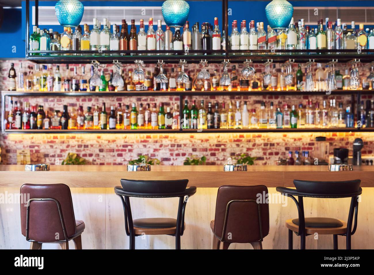 Il posto dove andare a Buon divertimento. Shot di un bar immacolato con molte bottiglie e bicchieri senza persone. Foto Stock