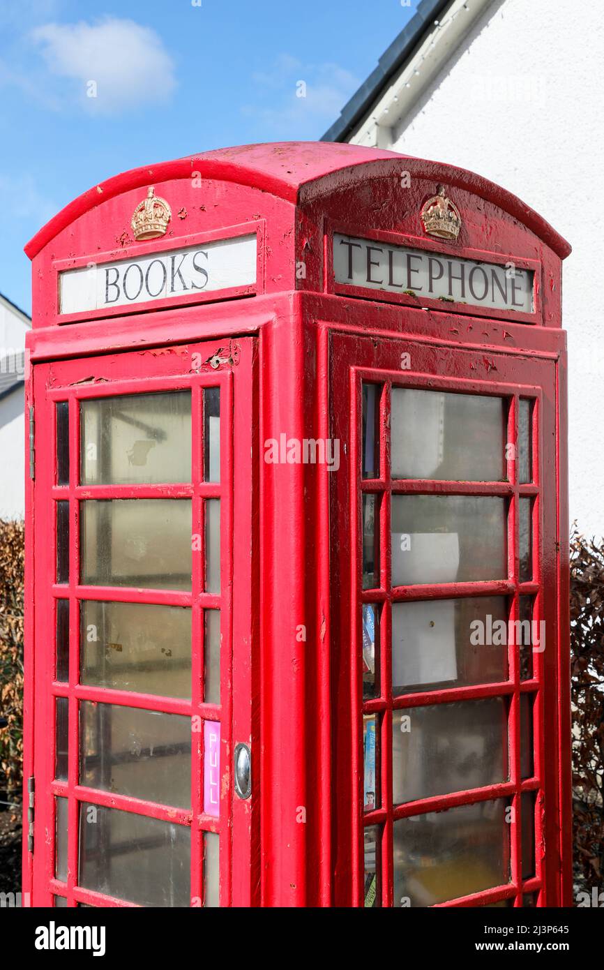 Vecchia scatola telefonica tradizionale GPO rossa disusata ora convertita in una biblioteca, per la condivisione gratuita dei libri, Fenwick, Ayrshire, Scozia, Regno Unito Foto Stock