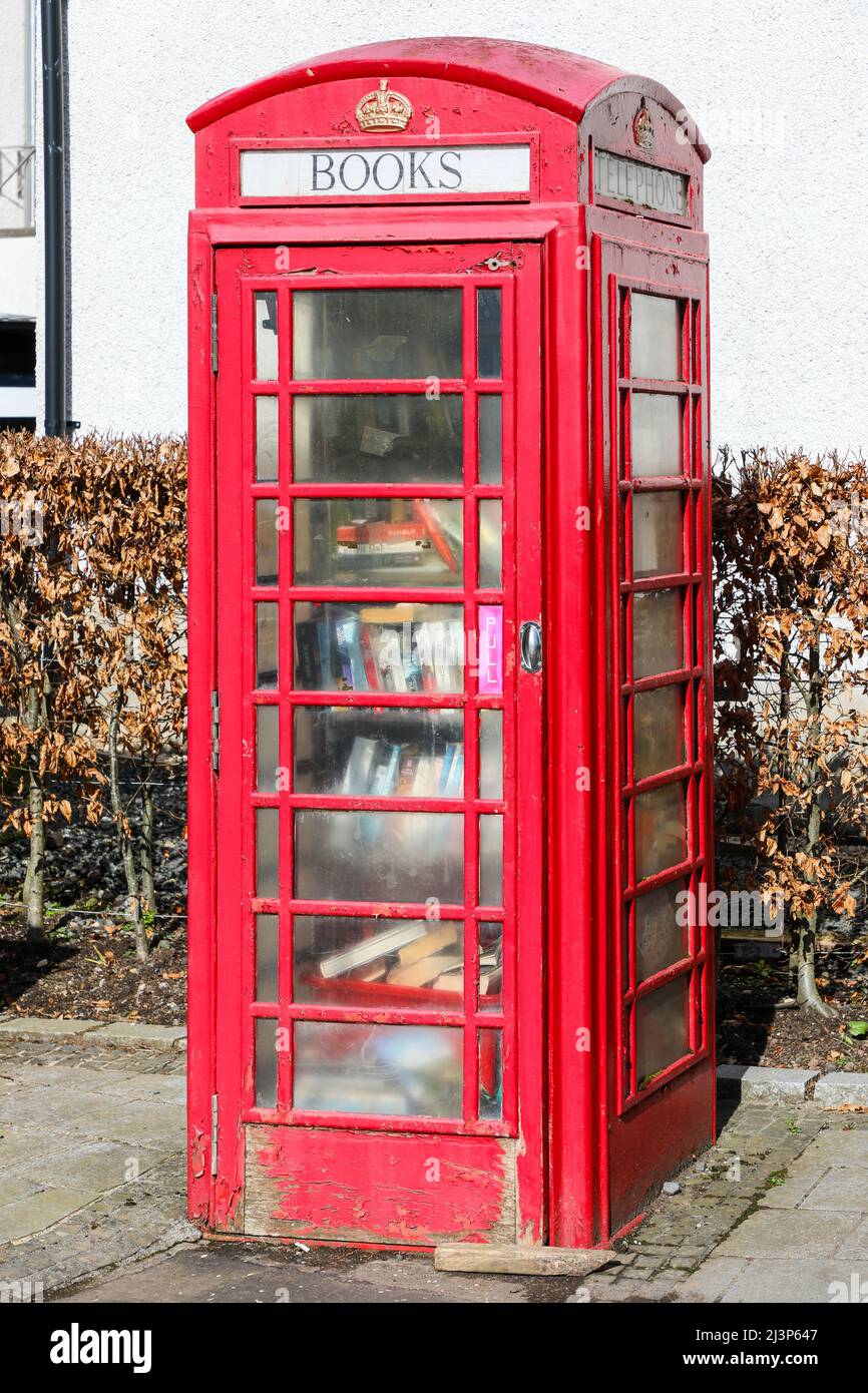 Vecchia scatola telefonica tradizionale GPO rossa disusata ora convertita in una biblioteca, per la condivisione gratuita dei libri, Fenwick, Ayrshire, Scozia, Regno Unito Foto Stock