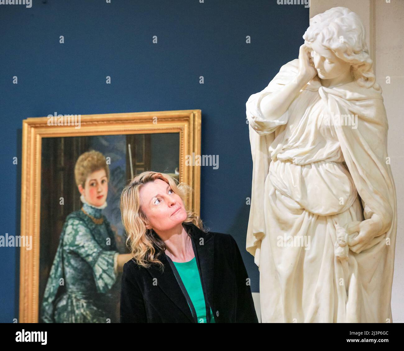 Londra, Regno Unito. 09th Apr 2022. Una galleria volontaria con il dipinto 'il violinista', di George Adolphus e Edwin Roscoe Mullins statua 'igon', 1881-83, ispirato da Mignon nella versione operatica francese dell'apprendistato di Goethe 'Wilhelm Meister'. La mostra "Inspired: Art Inspired by Theatre, Letterature and Music" della Guildhall Art Gallery mostra la collezione della City of London Corporation mentre la galleria si riapre al pubblico. 'Inspired' rivela come diverse forme d'arte si interconnettano e si ispirano. Credit: Imagplotter/Alamy Live News Foto Stock