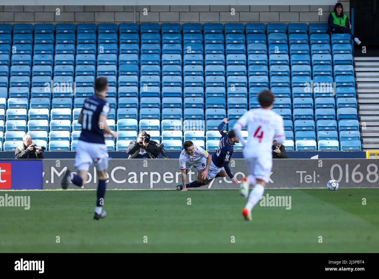 The Den, Millwall, Londra, Regno Unito. 9th Apr 2022. Campionato di calcio, Millwall contro Barnsley: Un viaggio da Liam Kitching di Barnsley su Oliver Burke di Millwall appena fuori della zona. Credit: Action Plus Sports/Alamy Live News Foto Stock