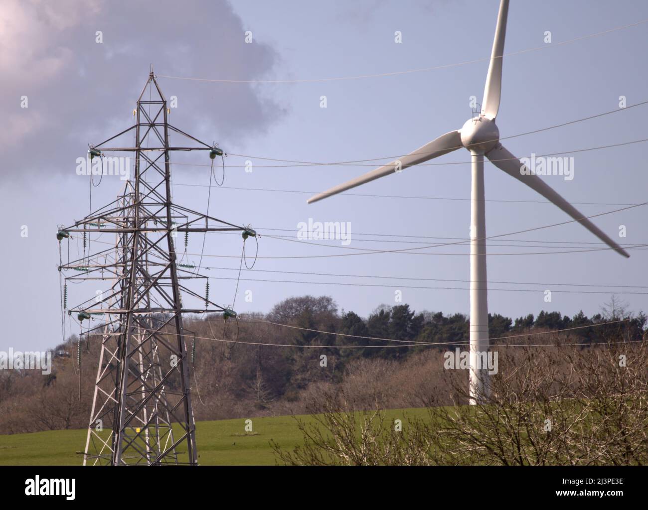 Produzione e distribuzione di energia, turbine eoliche rinnovabili, linee aeree e piloni per la trasmissione e la distribuzione di energia Foto Stock