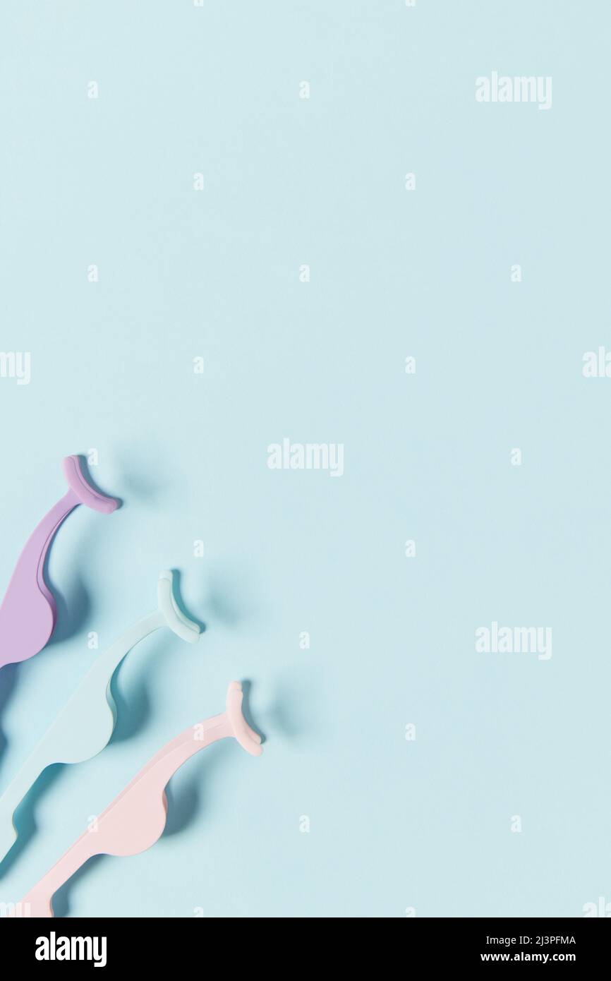 Applicatori con vista dall'alto Flat Lay per false ciglia su sfondo blu Foto Stock