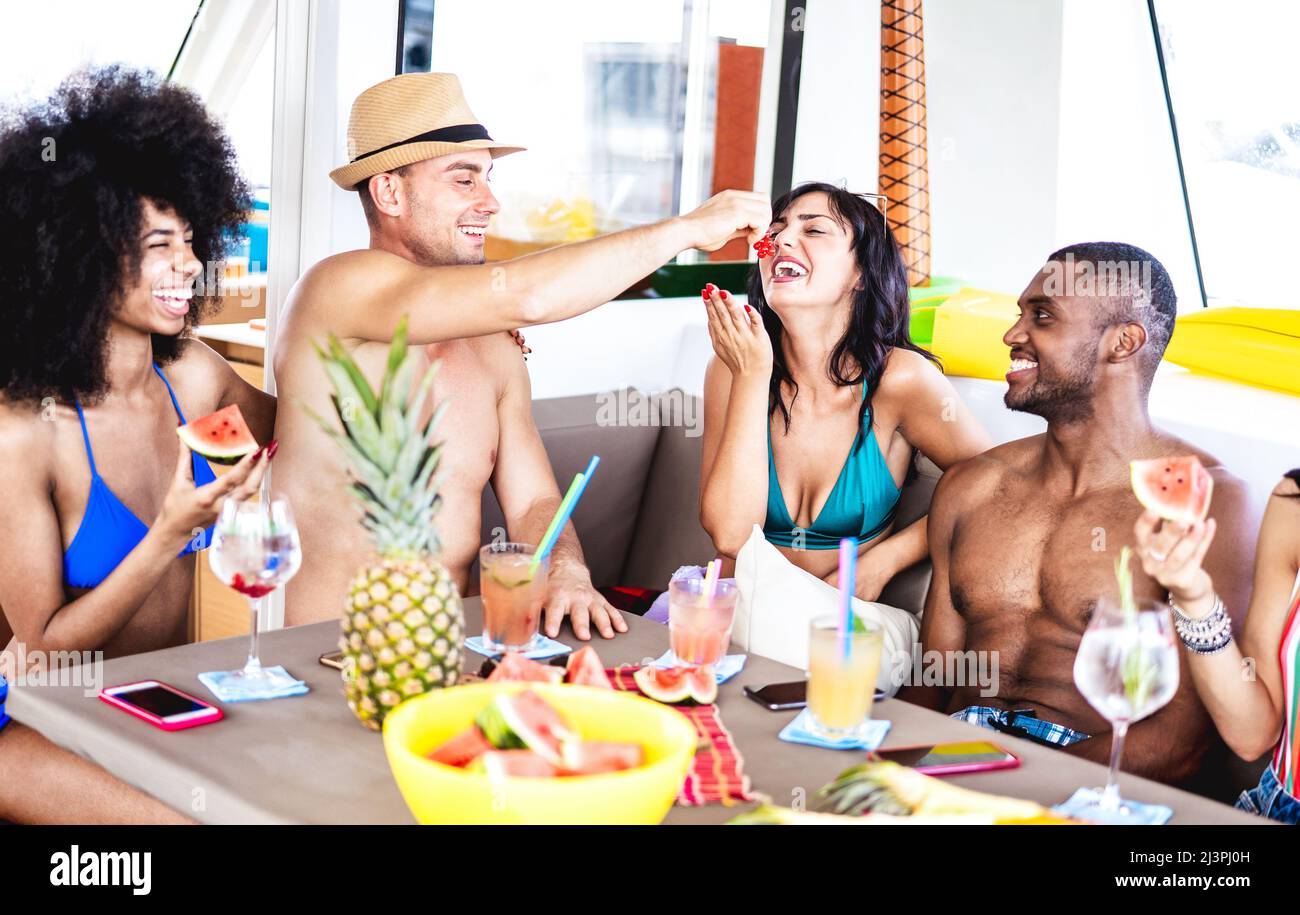 Gente alla moda che beve cocktail tropicali alla festa della barca - giovani amici milleniali che si divertono in vacanza di lusso - concetto di stile di vita di viaggio Foto Stock