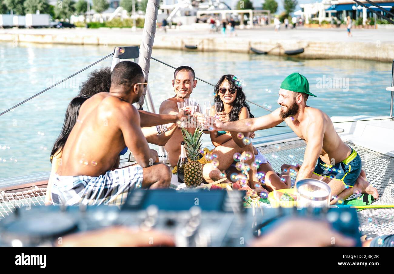 Amici alla moda che si divertono a tostare il vino a festa in barca a vela - Friendship Travel concetto di stile di vita con gente multirazziale in barca a vela Foto Stock