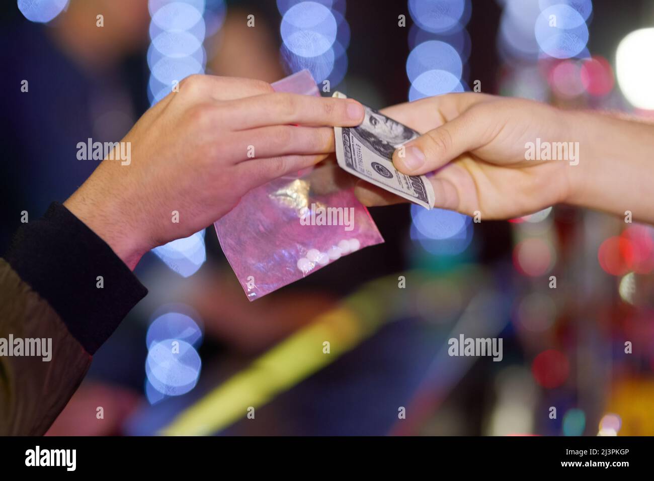 I partys che escono di mano. Closeup shot di una donna che acquista ecstasy da un commerciante in un nightclub. Foto Stock