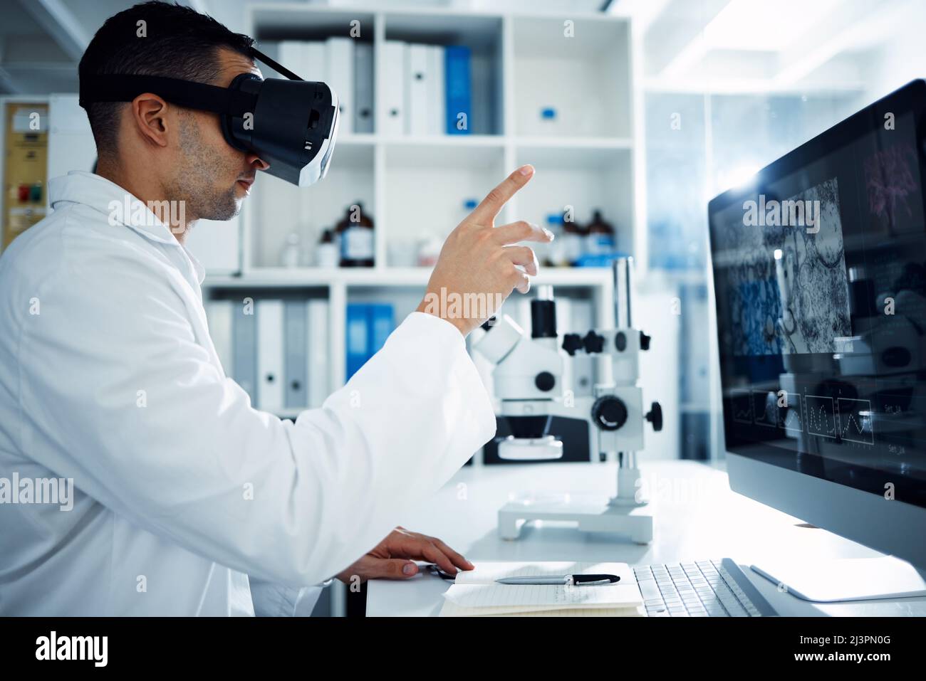 Il futuro è riservato ai progressisti. Foto di uno scienziato che utilizza una cuffia per realtà virtuale durante la ricerca in laboratorio. Foto Stock