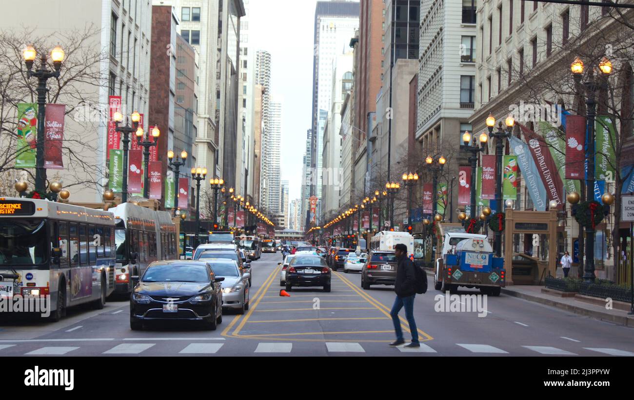 CHICAGO, ILLINOIS, STATI UNITI - DEC 11, 2015: Canyon urbani tra grattacieli del centro, con le automobili in primo piano Foto Stock