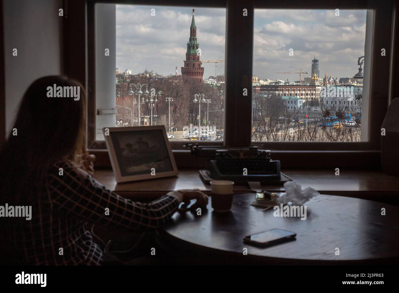 Mosca, Russia. 9th aprile 2022. Una ragazza beve un caffè nella caffetteria della Casa Pashkov con vista sul Cremlino di Mosca, Russia Foto Stock