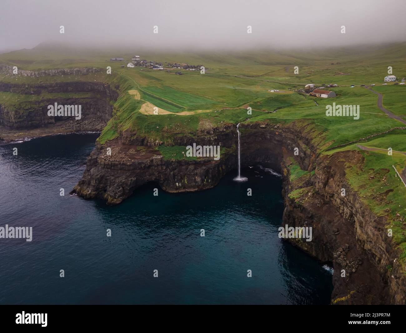 Bella vista aerea della cascata Gasadalur e villaggio e paesaggi nelle Isole Faroe Foto Stock