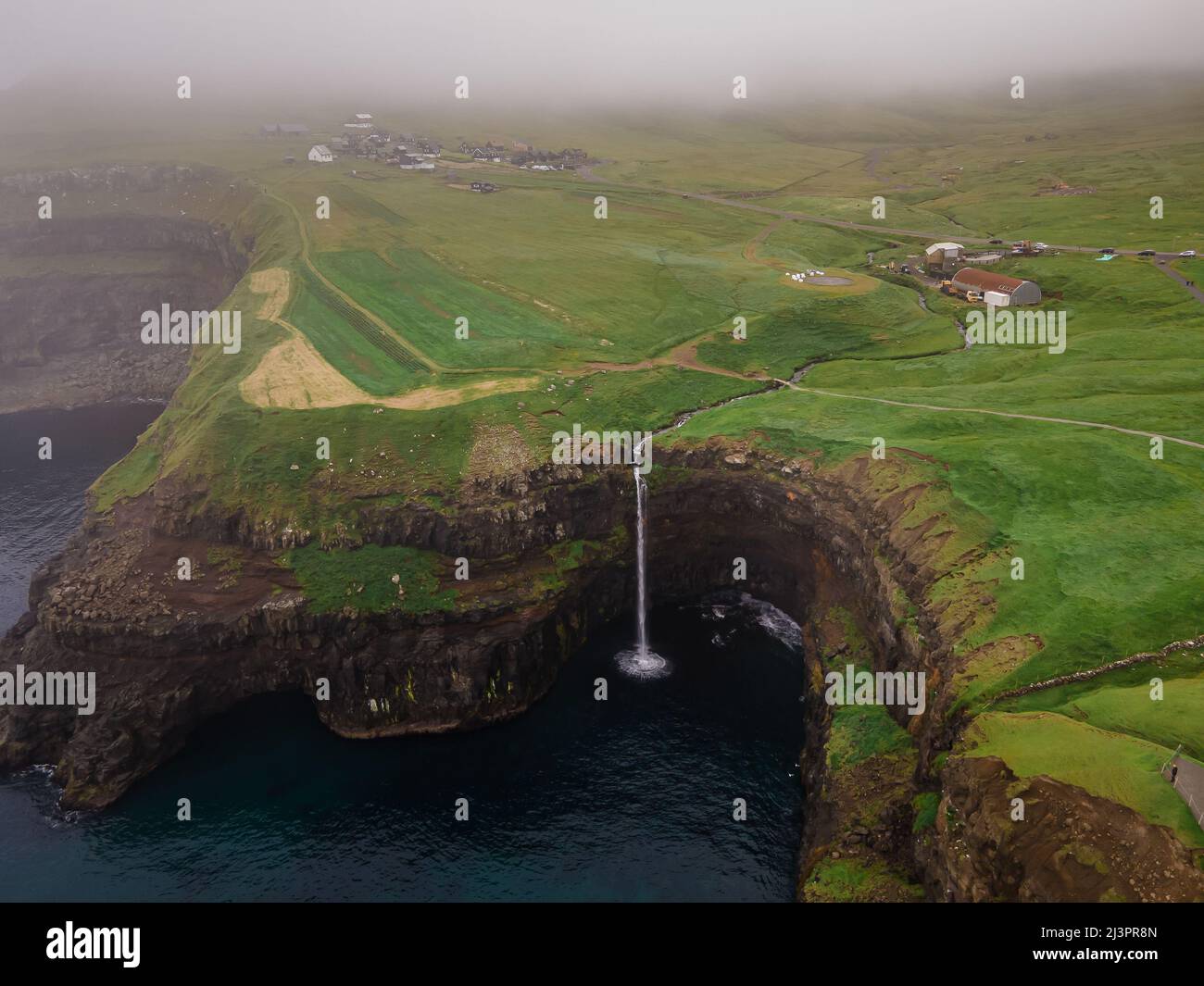 Bella vista aerea della cascata Gasadalur e villaggio e paesaggi nelle Isole Faroe Foto Stock