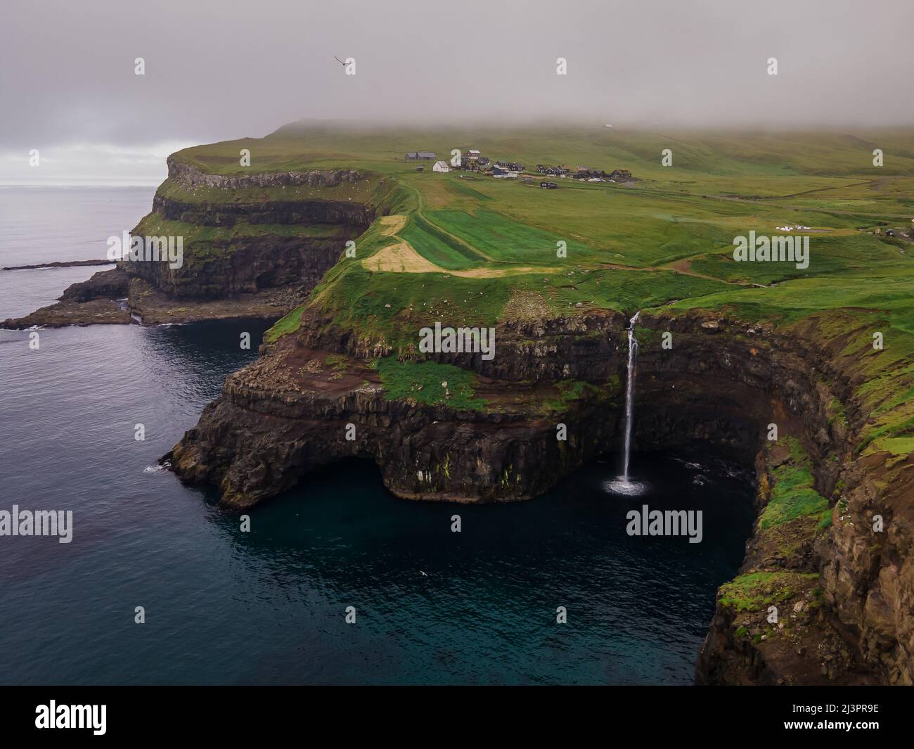 Bella vista aerea della cascata Gasadalur e villaggio e paesaggi nelle Isole Faroe Foto Stock