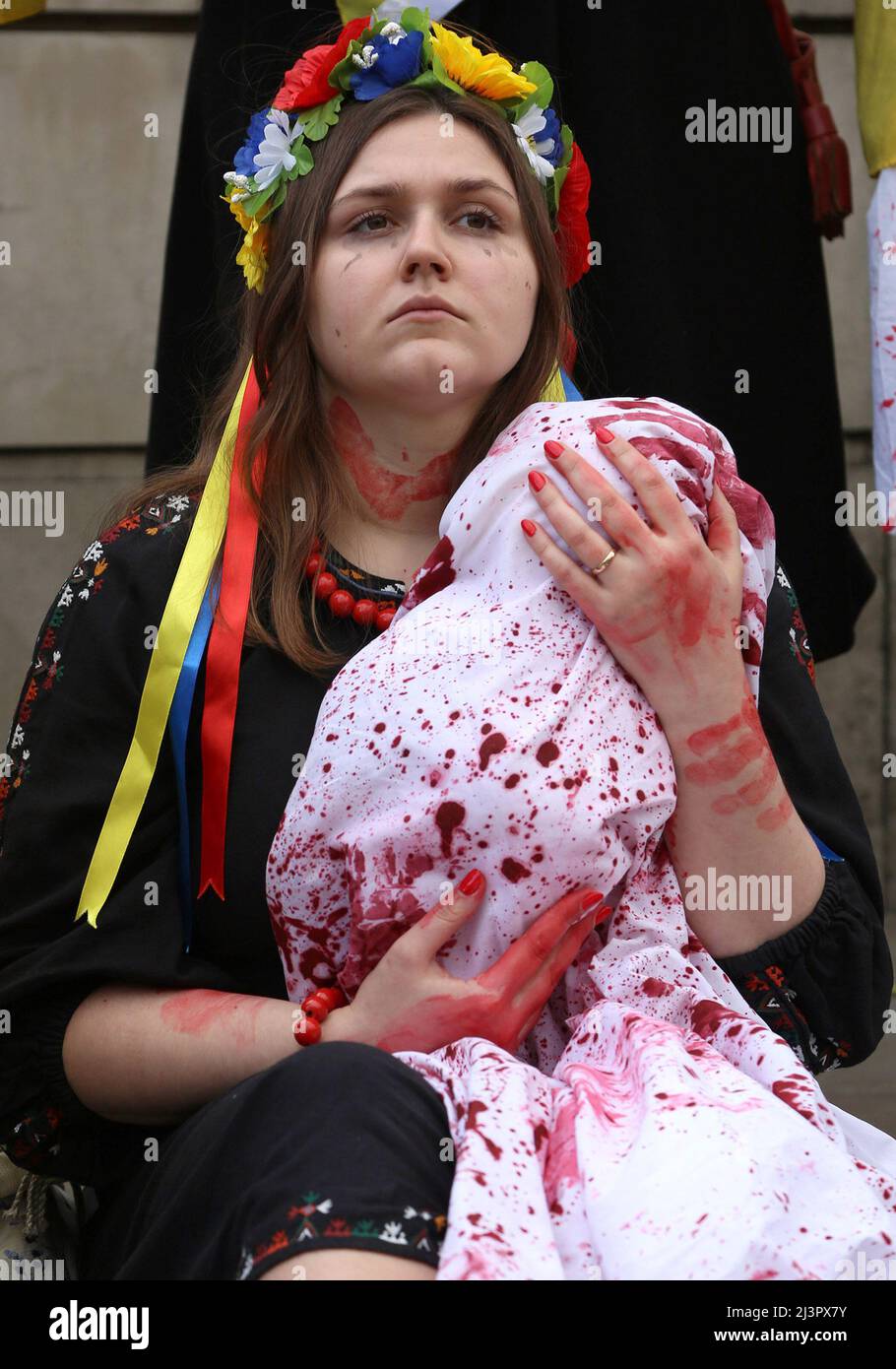 Una donna tiene un bambino falso, coperto di sangue, in memoria di quelli uccisi di recente a Bucha, Ucraina. La protesta si è tenuta fuori Downing Street, Londra, chiedendo ulteriori aiuti dal Regno Unito in Ucraina. Aprile 9th 2022. Anna Hatfield/Pathos Foto Stock