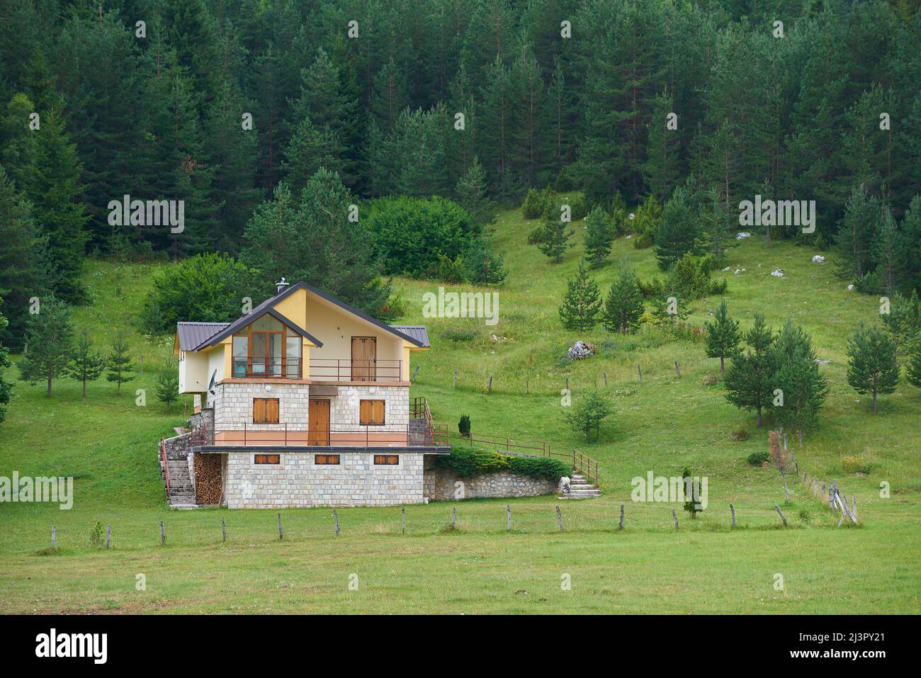 Casa di campagna vicino alla foresta in montagna con finestre chiuse. Foto Stock