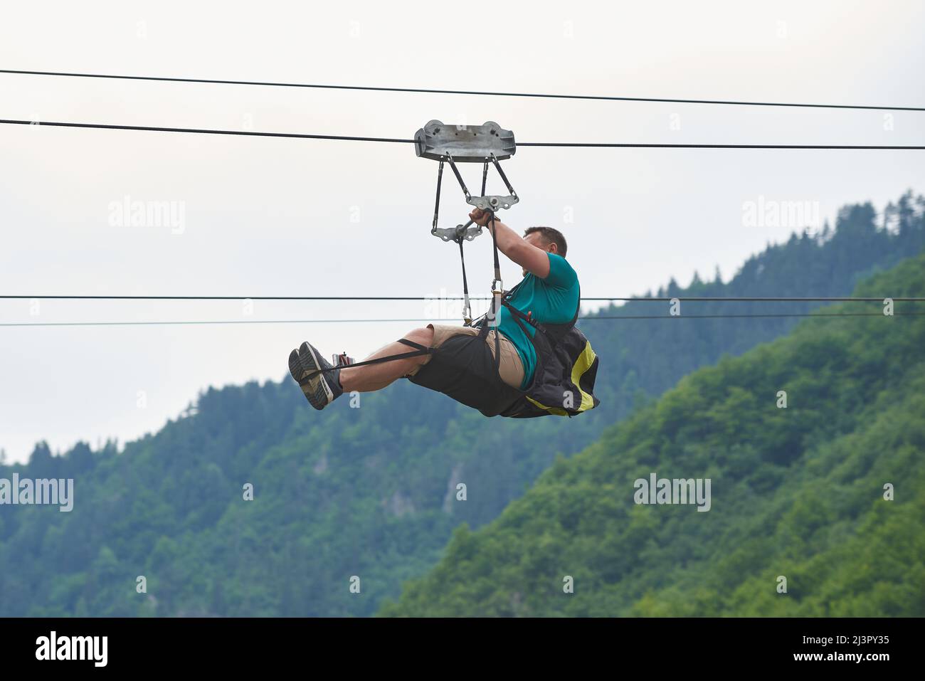 Un uomo corre una zipline in Montenegro Foto Stock